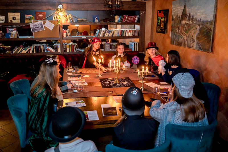 Дети разгадывают загадки в семейном квесте Хэллоуина в Arkhangelsk